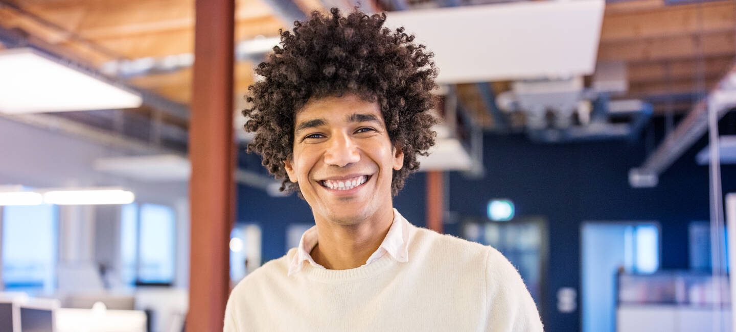 Student schaut lachend in die Kamera