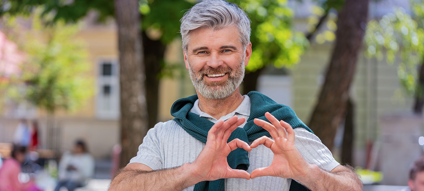 Alter Mann bildet mit der Hand ein Herrz