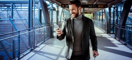 Mann schaut auf Handy | Hallesche