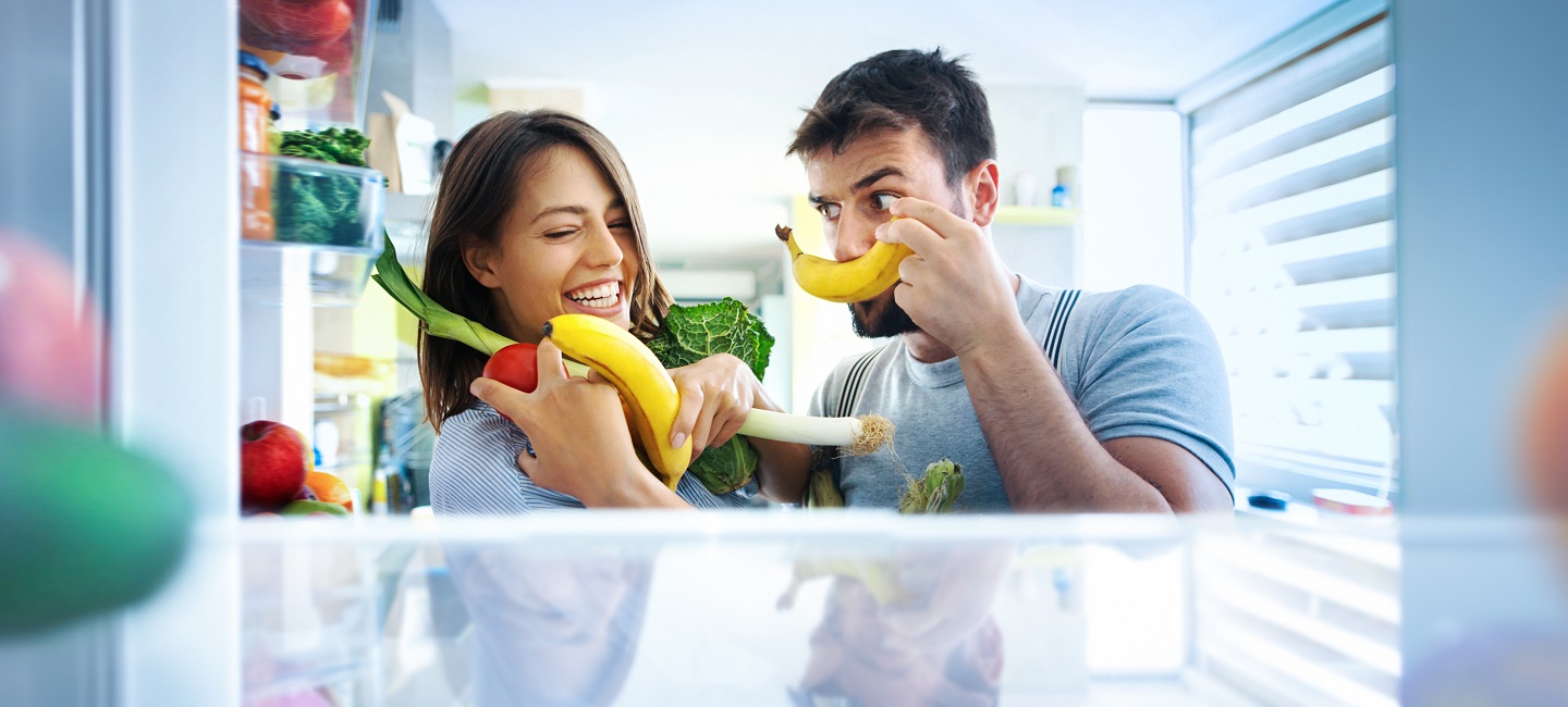 Frau und Mann machen Witze mit Obst